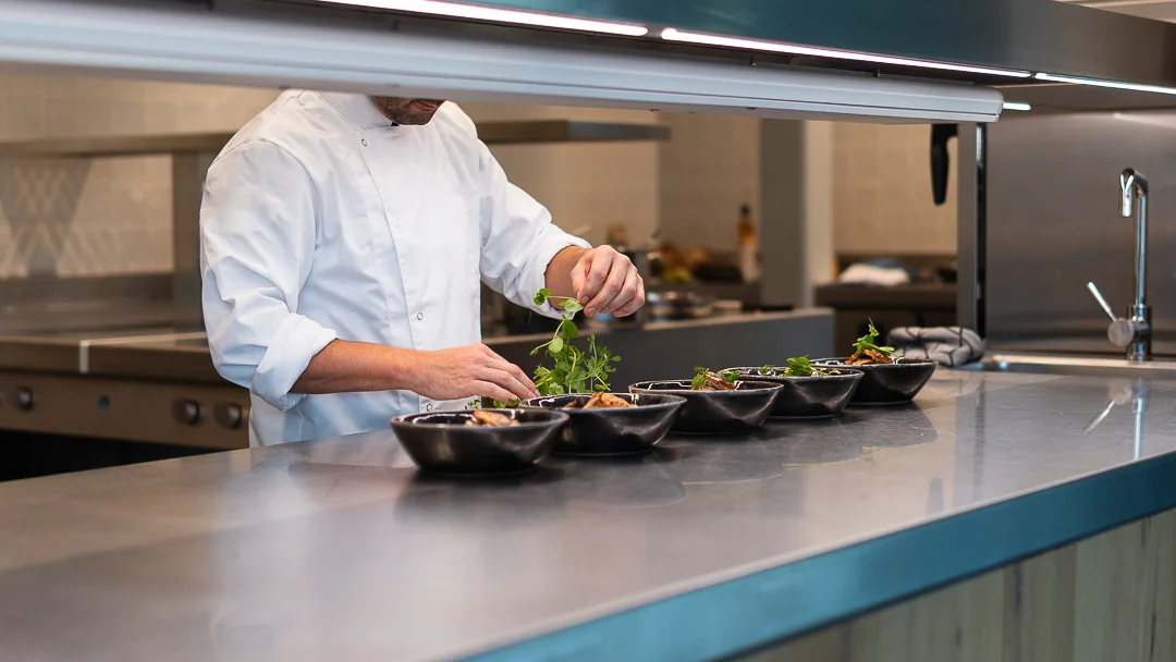 Le chef dresse les assiettes au passe de la cuisine