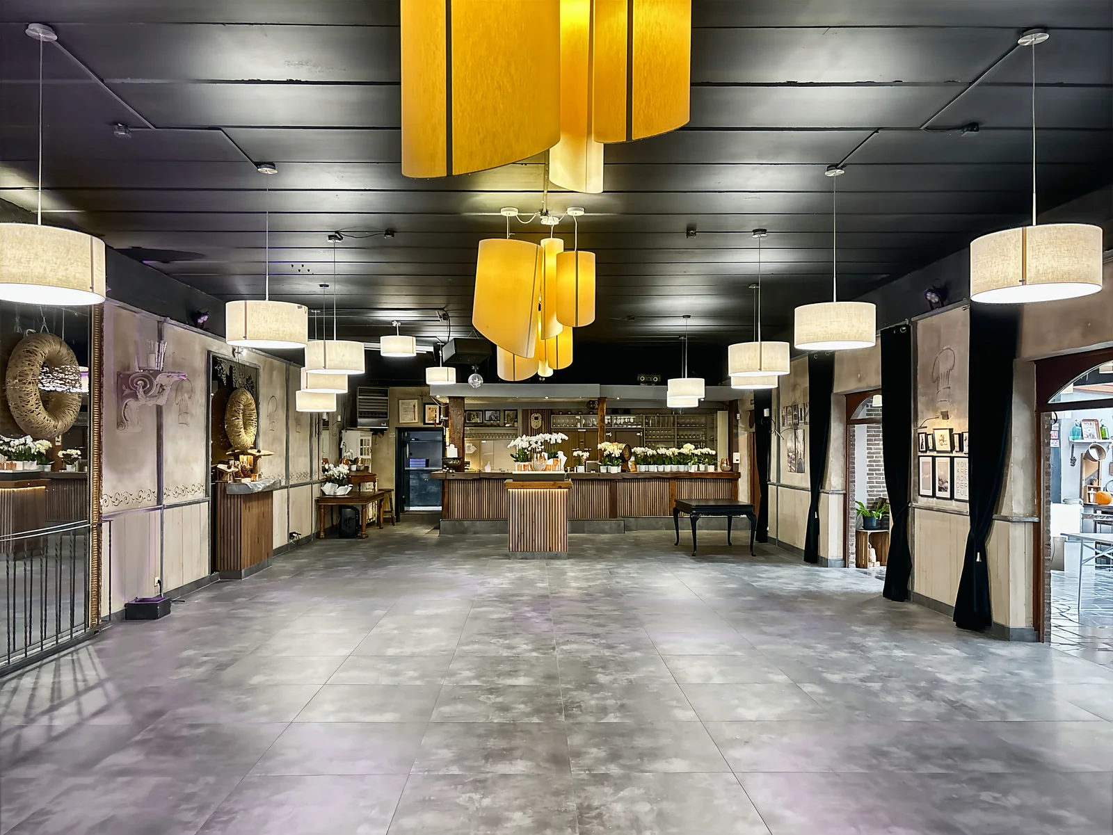 La grande salle vue sur toute sa longueur, jusqu’au bar